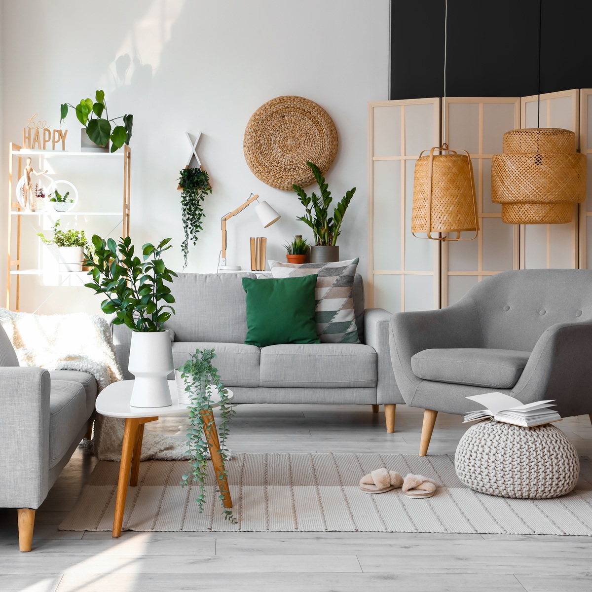 Interior of bright living room with cozy sofas and armchair near big window